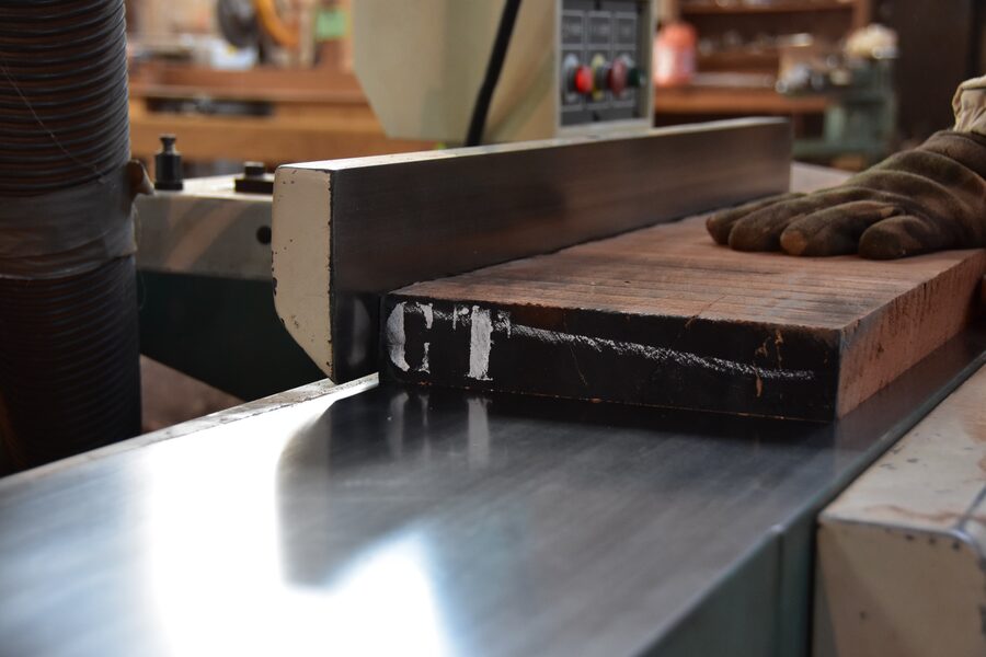 Hardwood board being face-jointed flat on the jointer at Estate Millwork