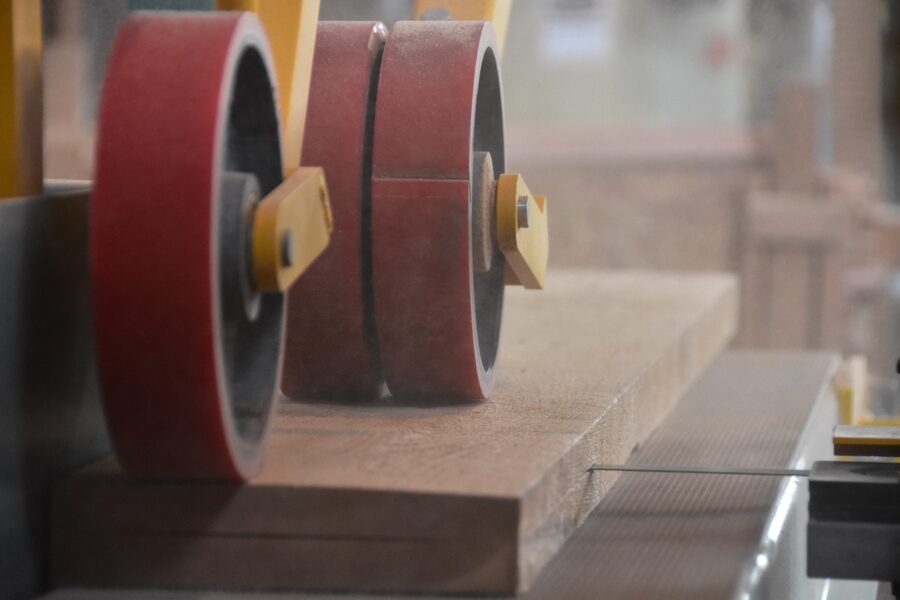 Solid mahogany door being surfaced on the wide-belt sander at Estate Millwork